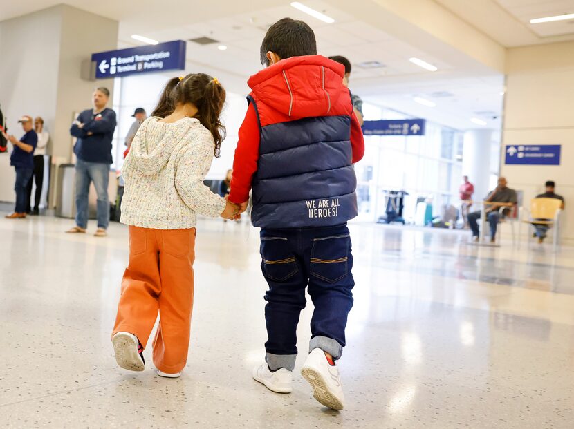 Wearing a ‘We Are All Heroes!’ jacket, Mohammad Yasin Ahmadzai, 4, (right) holds hands with...