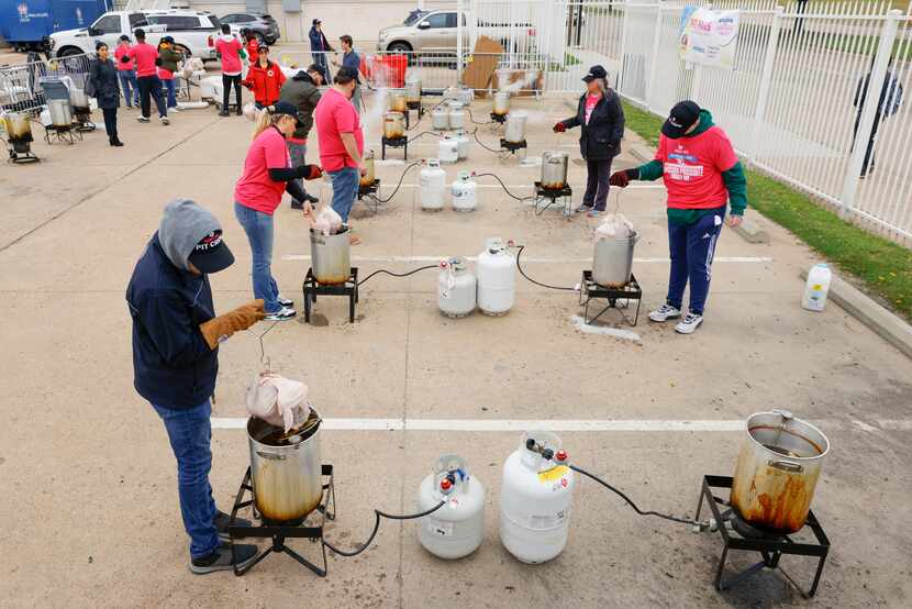 Volunteers dipped turkeys in pots during the annual Dallas LIFE Turkey Fry on Tuesday, Nov....