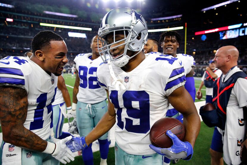 Dallas Cowboys wide receiver Amari Cooper (19) is congratulated on the sideline by fellow...