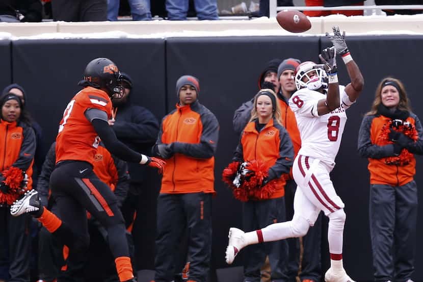 Oklahoma wide receiver Jalen Saunders (8) catches a pass in front of Oklahoma State safety...