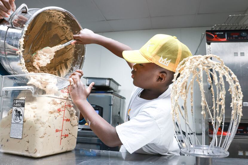 Dallas Wise, 12, scoops chocolate chip cookie dough into a container as his mother, Shanay,...