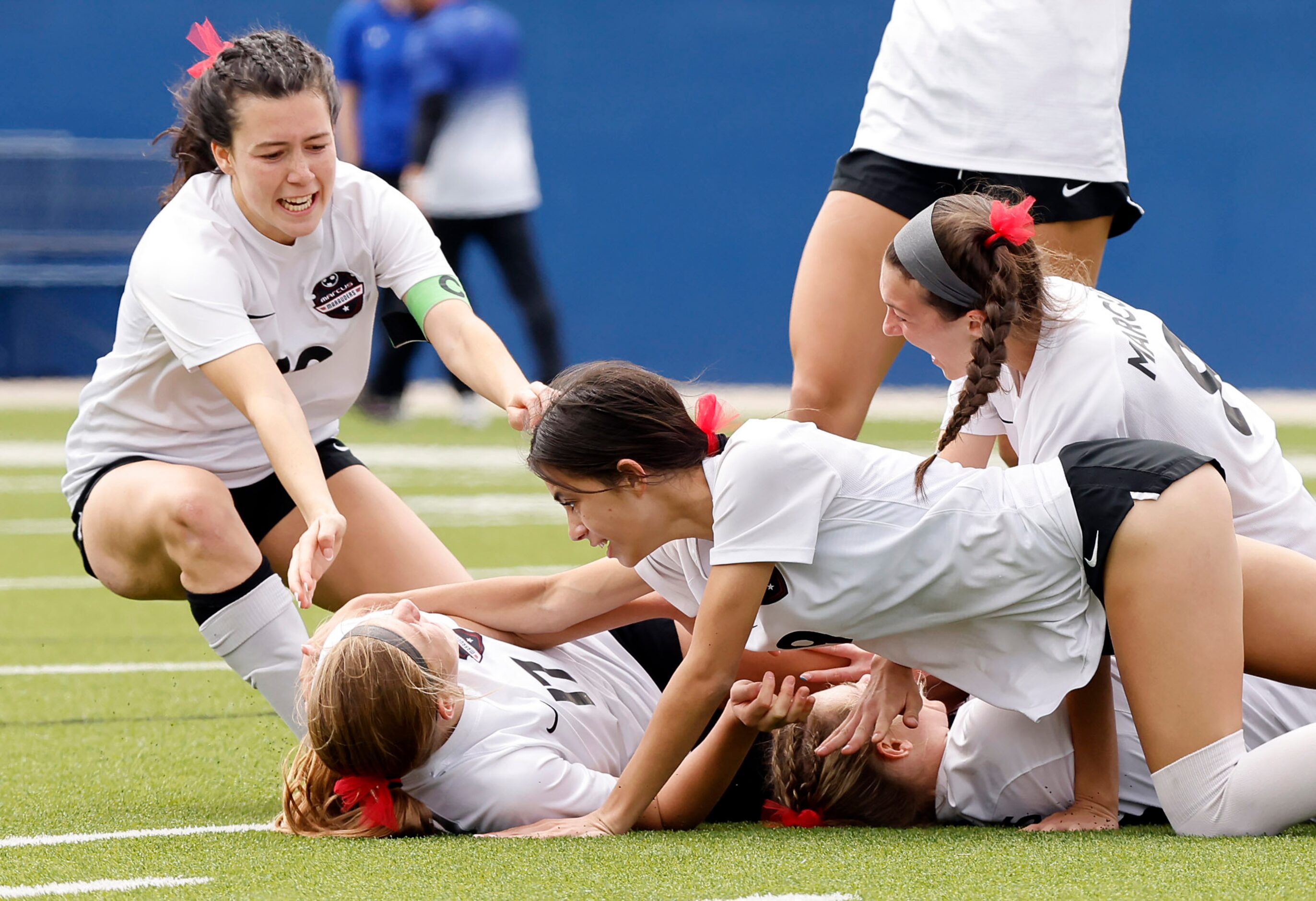 Teammates tackle Flower Mound Marcus’ Madi Patterson (17) after she scored the only goal...