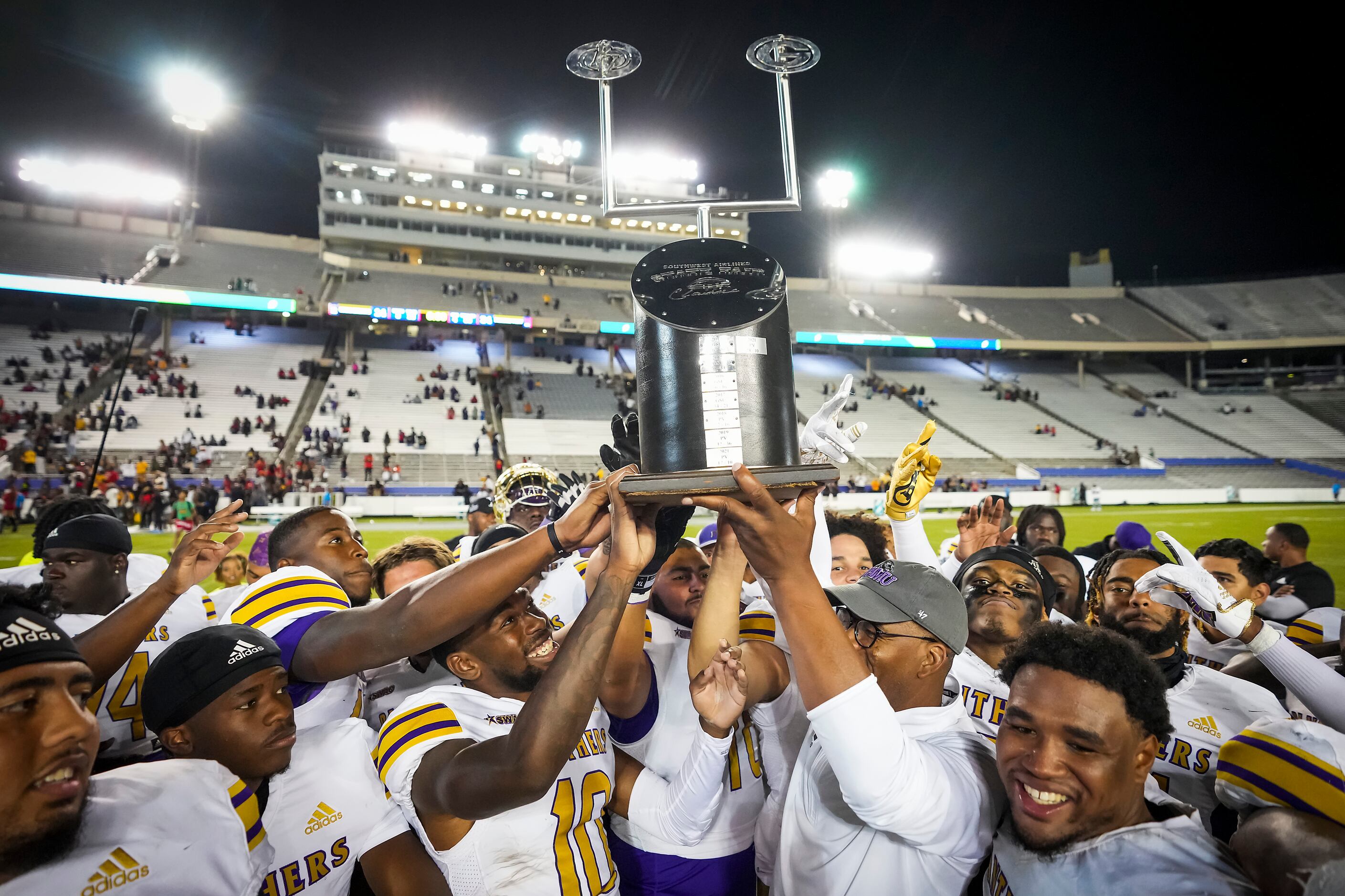 Prairie View head coach Bubba McDowell lifts the State Fair Classic trophy after a victory...