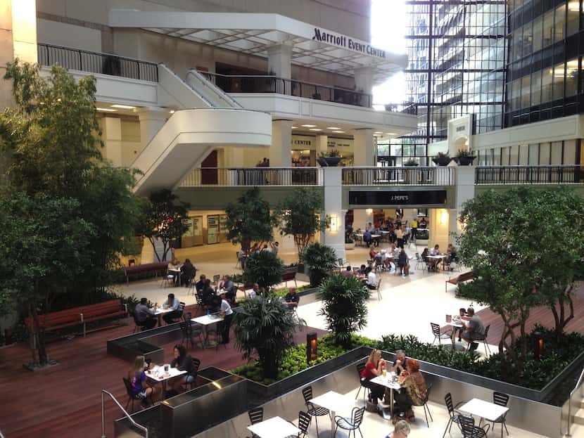 The 15-story atrium in the downtown Dallas office and retail project has a garden and dining...
