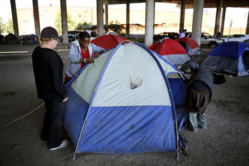 People pitch a tent under I-45 south of downtown after being kicked out Tent City Tuesday,...