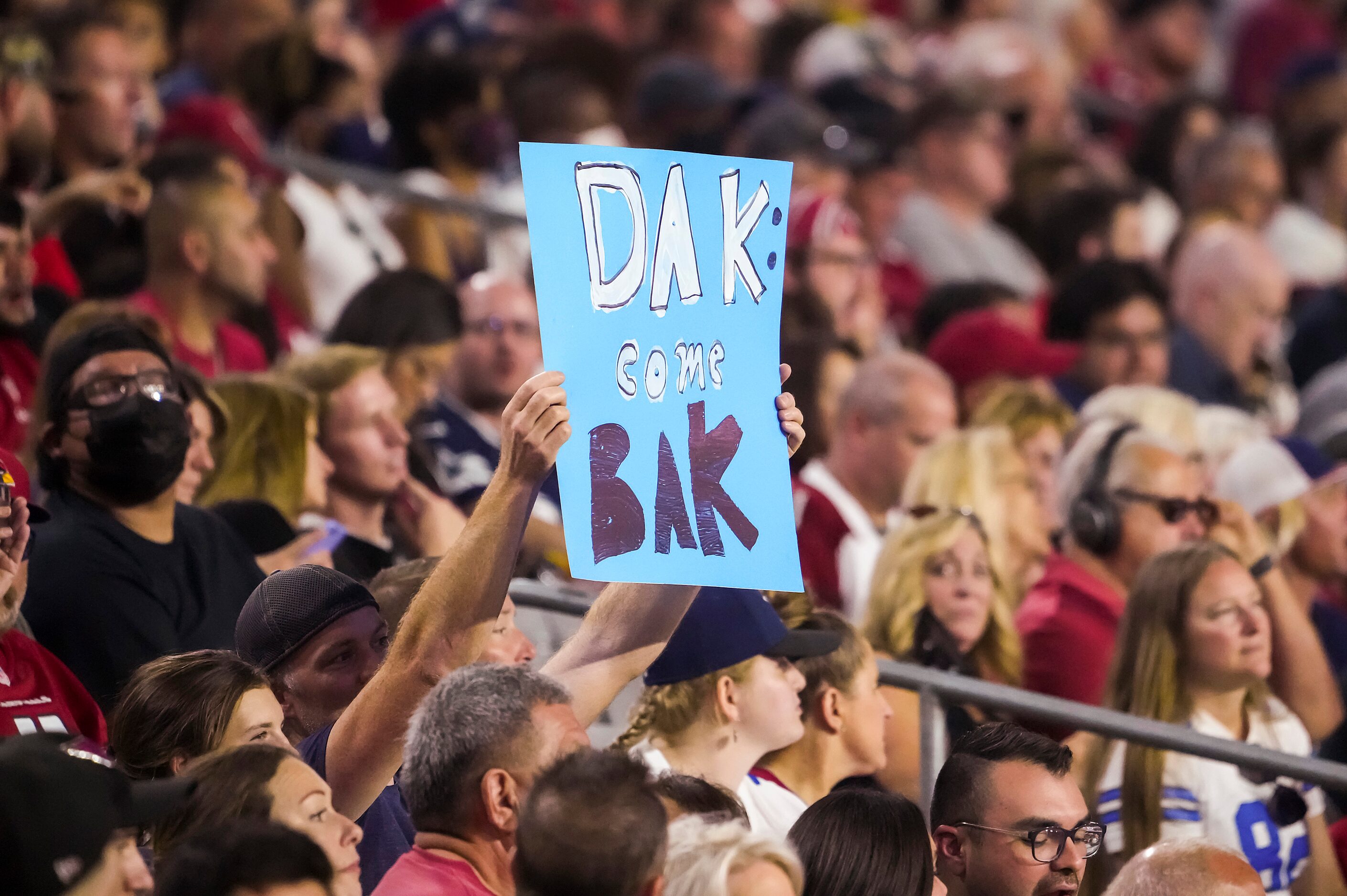 Fans hold a sign in support of Dallas Cowboys quarterback Dak Prescott during the first...