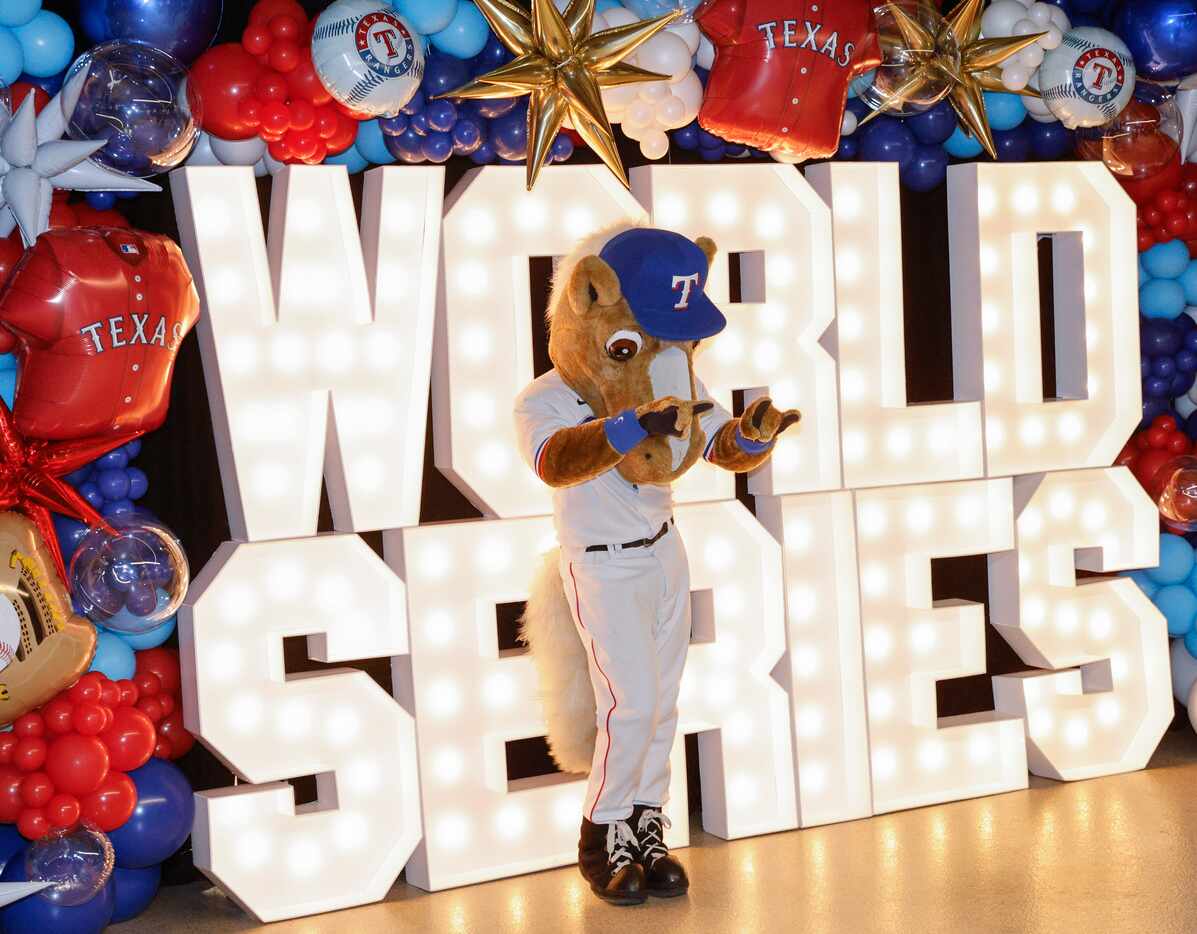 Texas Rangers mascot Capitan dances in front of a photo wall during a World Series Game 4...