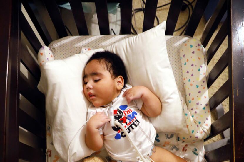 D'ashon Morris, who is in a vegetative state, rests in his crib as he receives his breakfast...