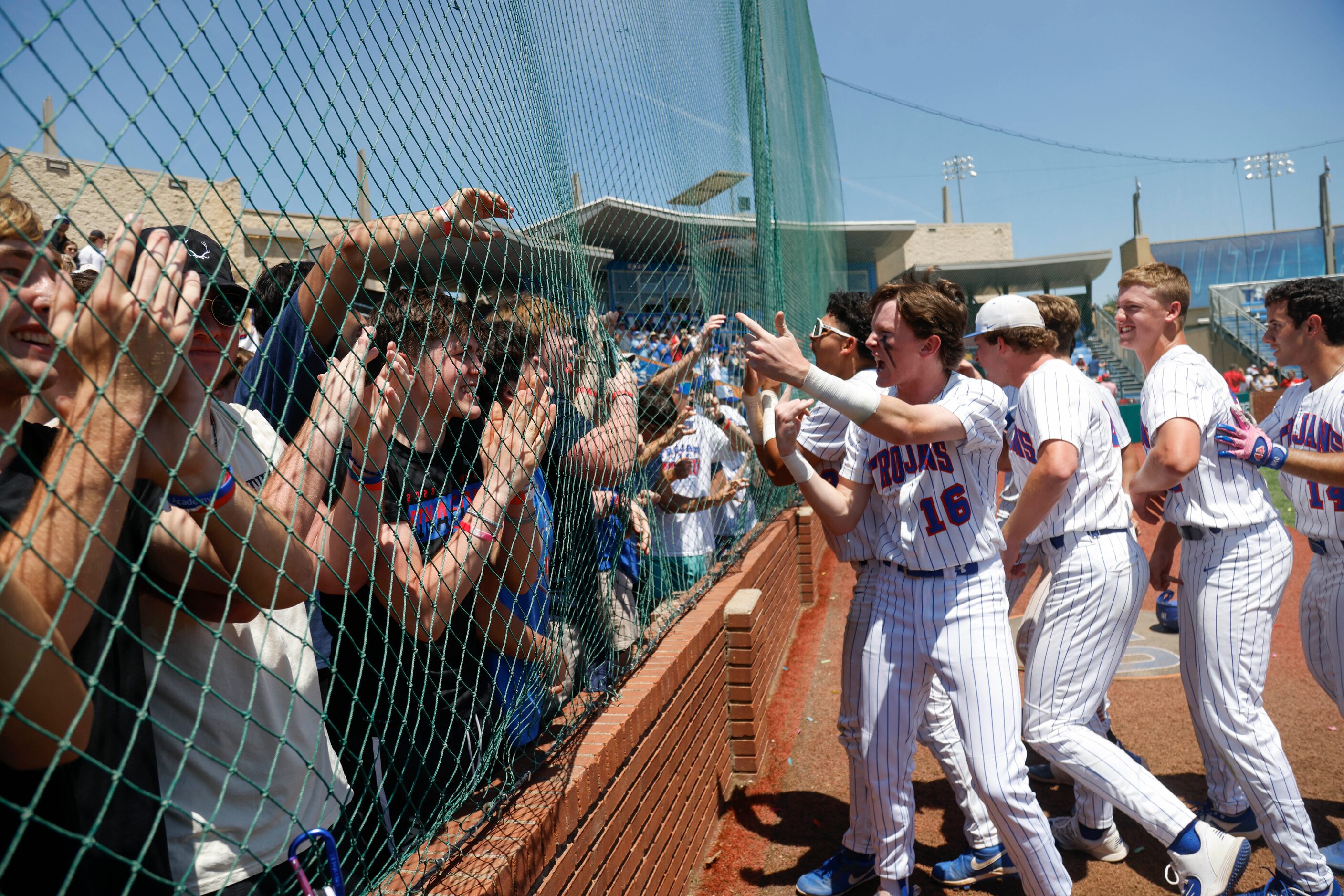 Trinity Christian’s Lleyton Myers (16) and teammates run to greet fans after defeating...