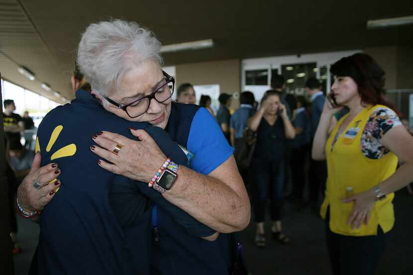 Walmart employees comfort one another after an active shooter opened fire at the store in El...