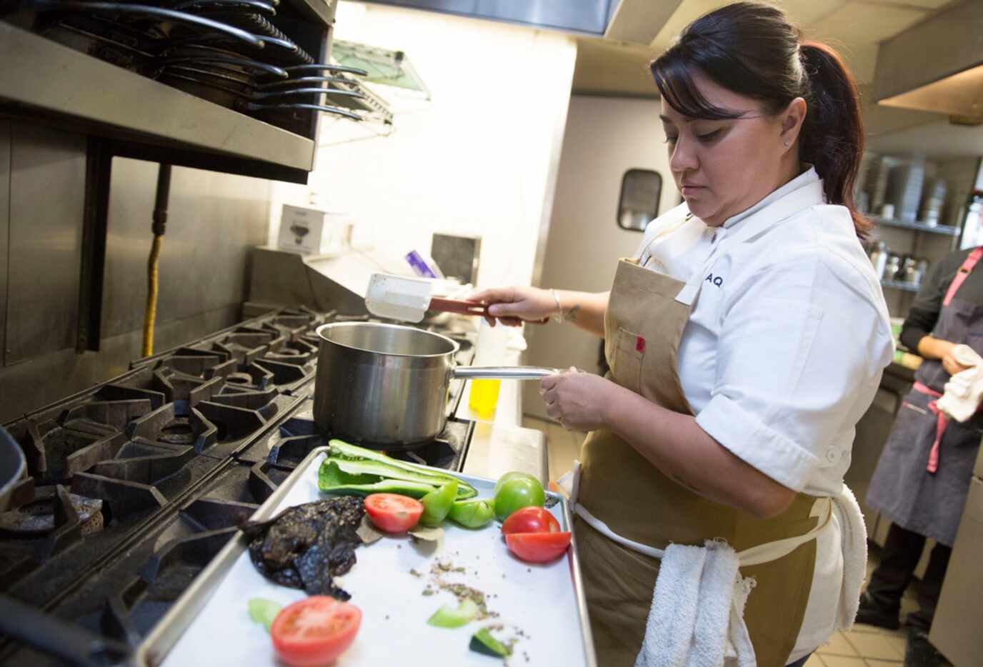 Cedars Social chef Anastacia Quinones (CQ) prepares mole in the kitchen at the restaurant in...