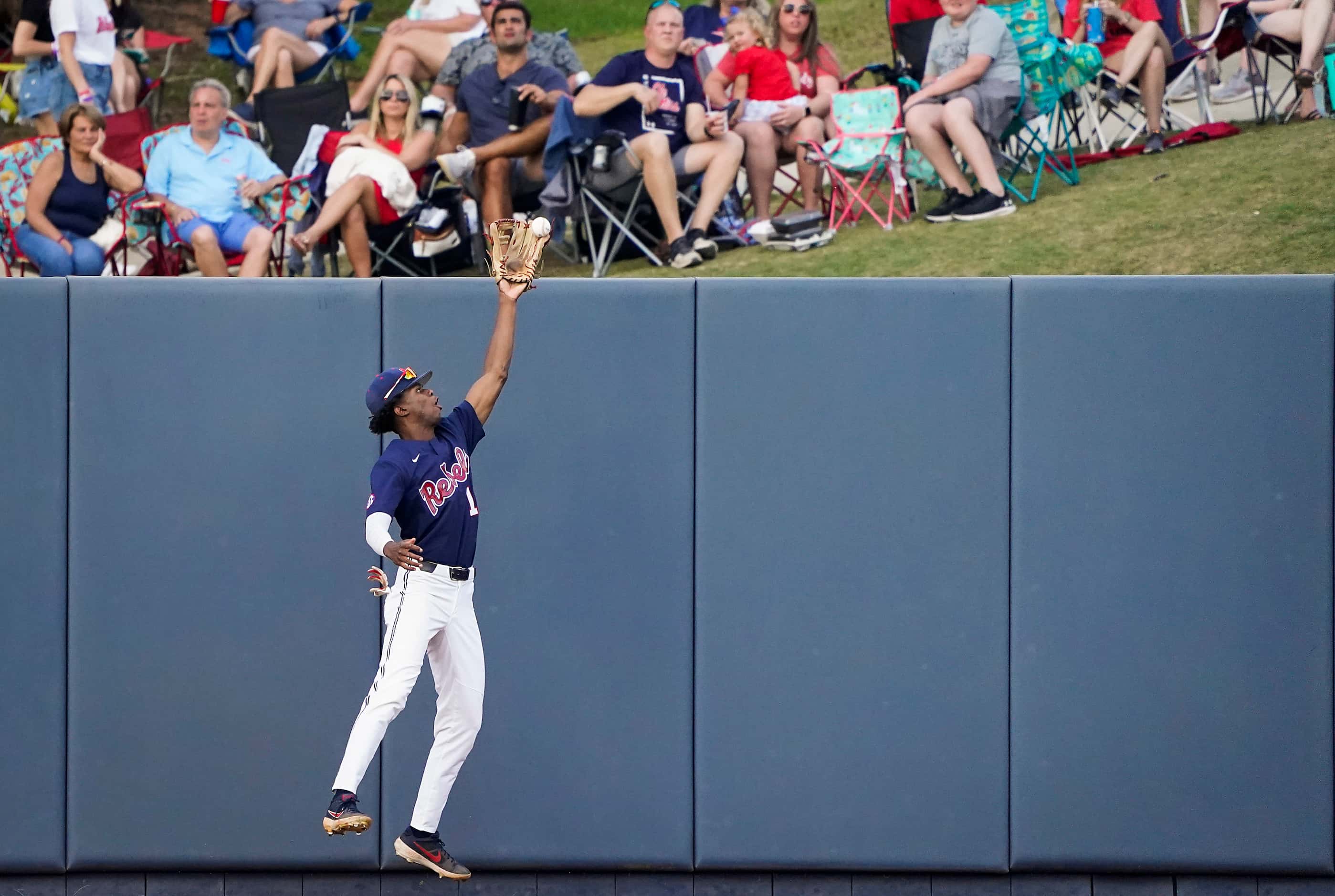 Mississippi center fielder TJ McCants makes a catch at the wall during an NCAA baseball game...