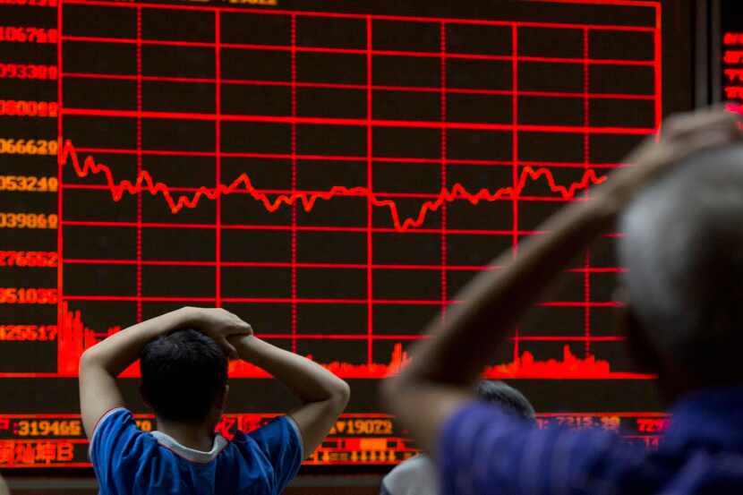 
Investors monitor a display showing the Shanghai Composite Index at a brokerage in Beijing....