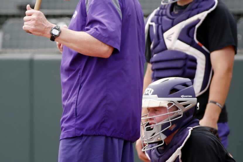 TCU manager Jim Schlossnagle throws a ball into the air while conducting drills during a...