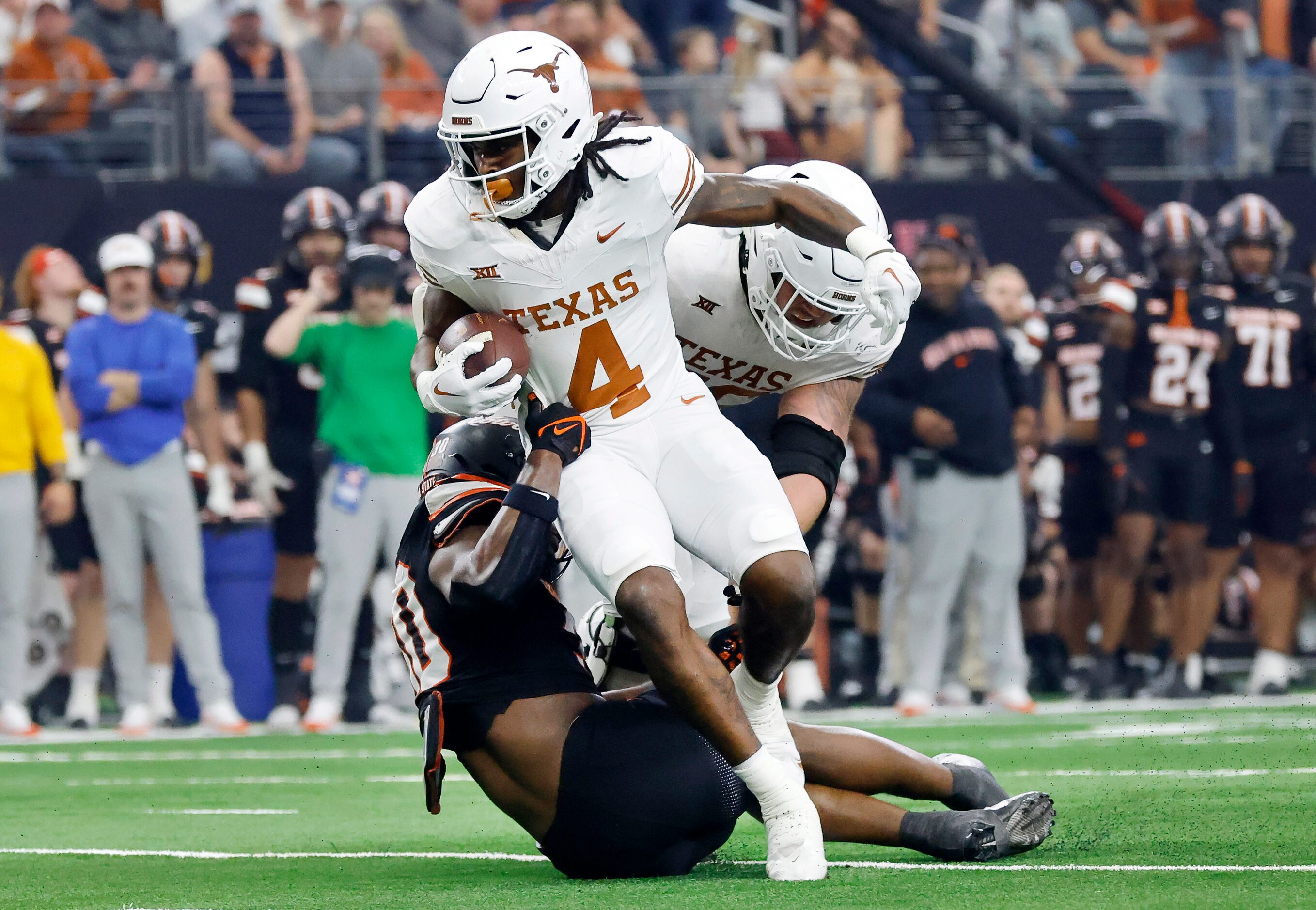 Texas Longhorns running back CJ Baxter (4) breaks free from Oklahoma State Cowboys...