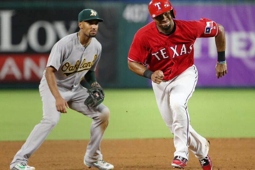 Texas Rangers shortstop Elvis Andrus (1) runs past Oakland Athletics shortstop Marcus Semien...