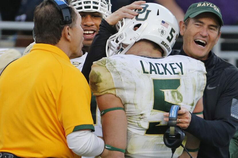 Baylor linebacker Eddie Lackey (5) gets a hug from head coach Art Briles, right, and...
