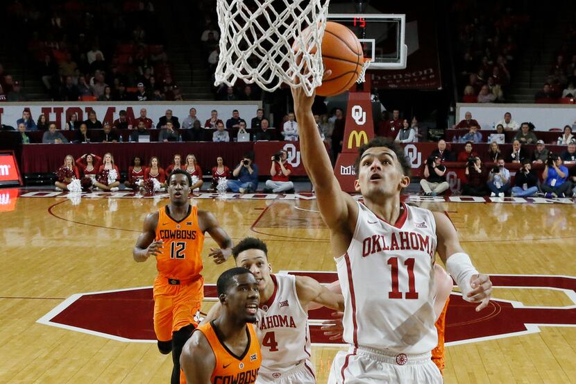 Oklahoma guard Trae Young (11) shoots in front of Oklahoma State guard Tavarius Shine (5)...