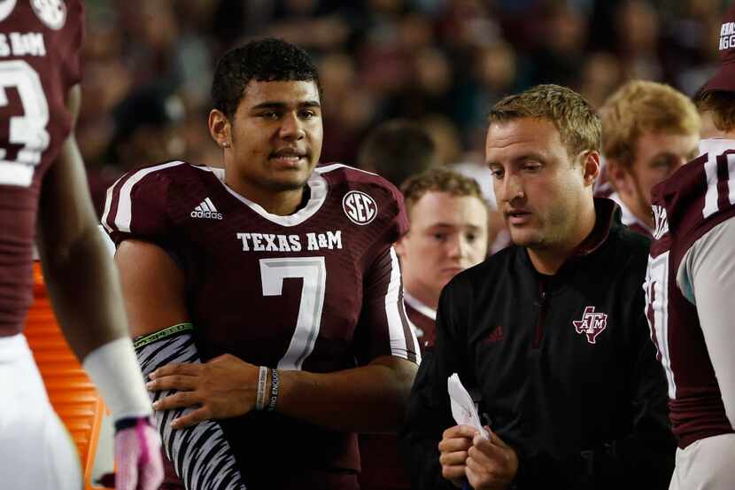 Kenny Hill #7 of the Texas A&M Aggies chats with quarterbacks coach Jake Spavital during the...