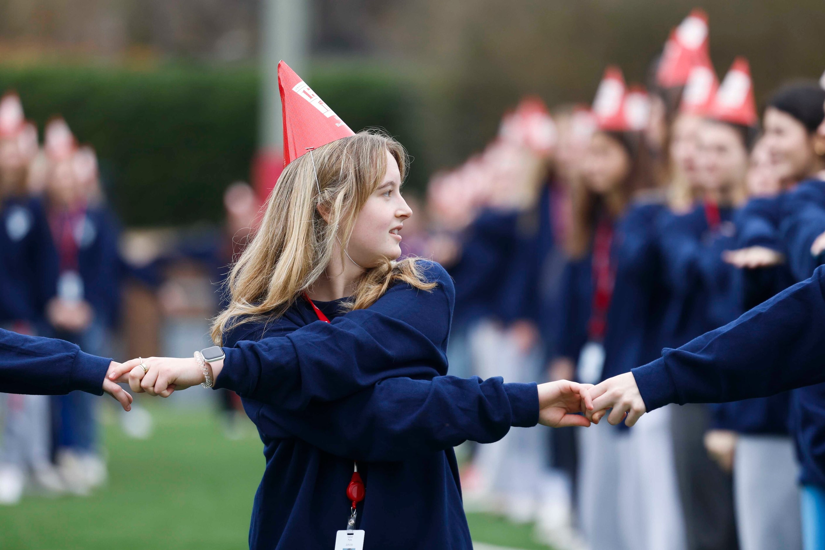 Student Isabel Pyle holds hands as she stands in formation of "UA 150" for a giant group...