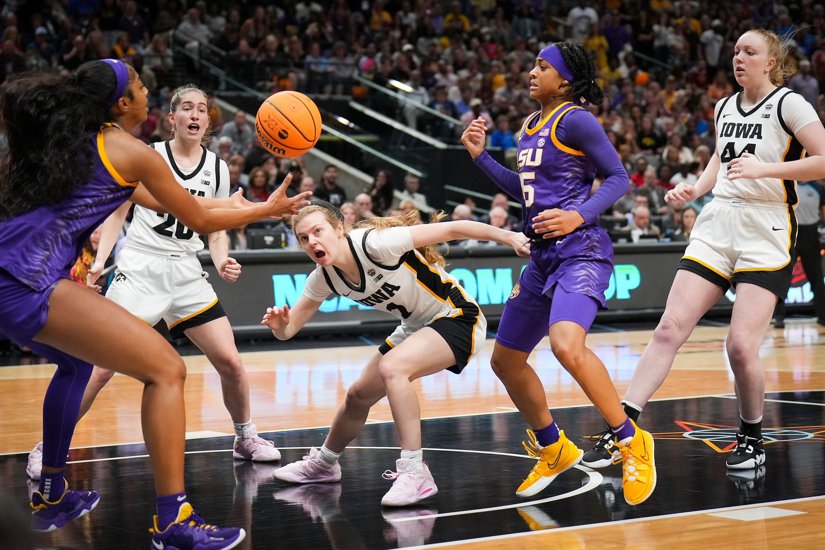 LSU forward Angel Reese (left) takes the ball away from Iowa guard Molly Davis (1) as guard...