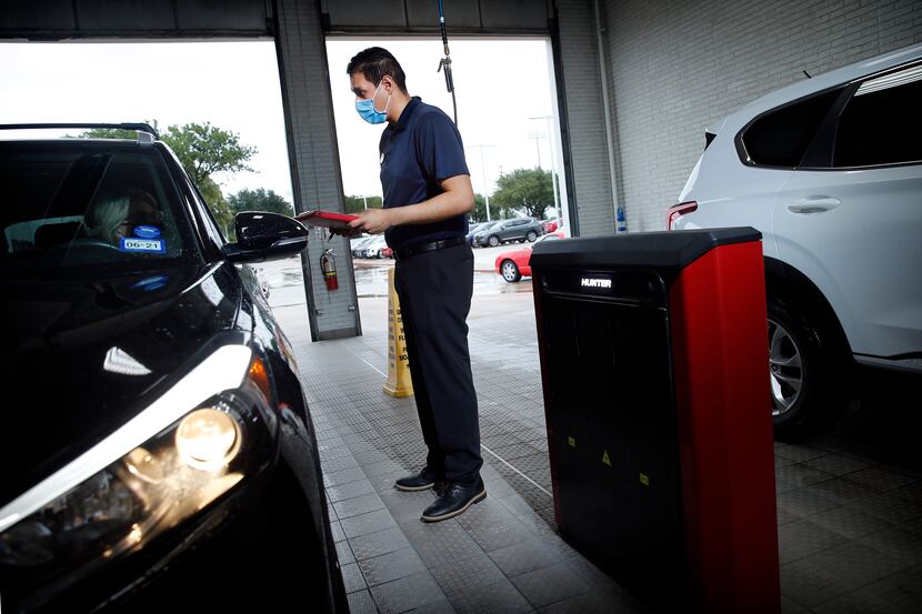 Service technician Eric Alejandraz check with a car owner about getting service at Huffines...