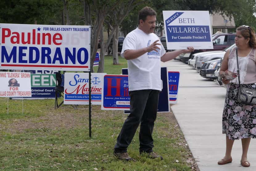Roman Gonzalez, left, tries to convince voter Monica Sauceda to cast her ballot for...