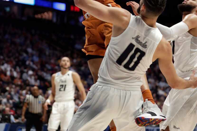 Texas forward Jericho Sims (20) goes up over Nevada forward Caleb Martin (10) in the first...