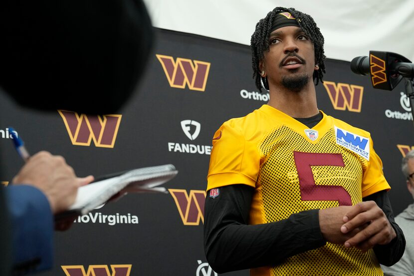 Washington Commanders first-round draft pick quarterback Jayden Daniels talks with reporters...