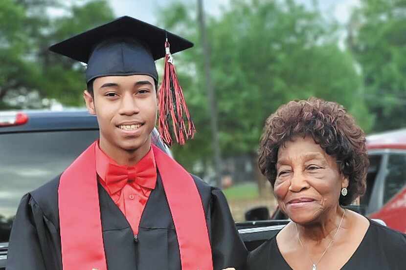 Dressed in cap and gown, Shamar Peoples stands next to his grandmother at his high school...