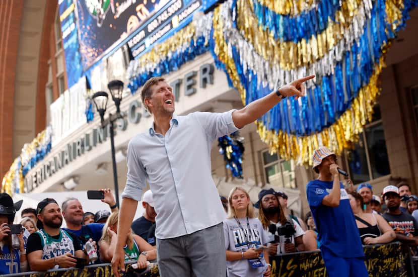 Former Dallas Mavericks player Dirk Nowitzki laughs with others as he shot hoops outside the...