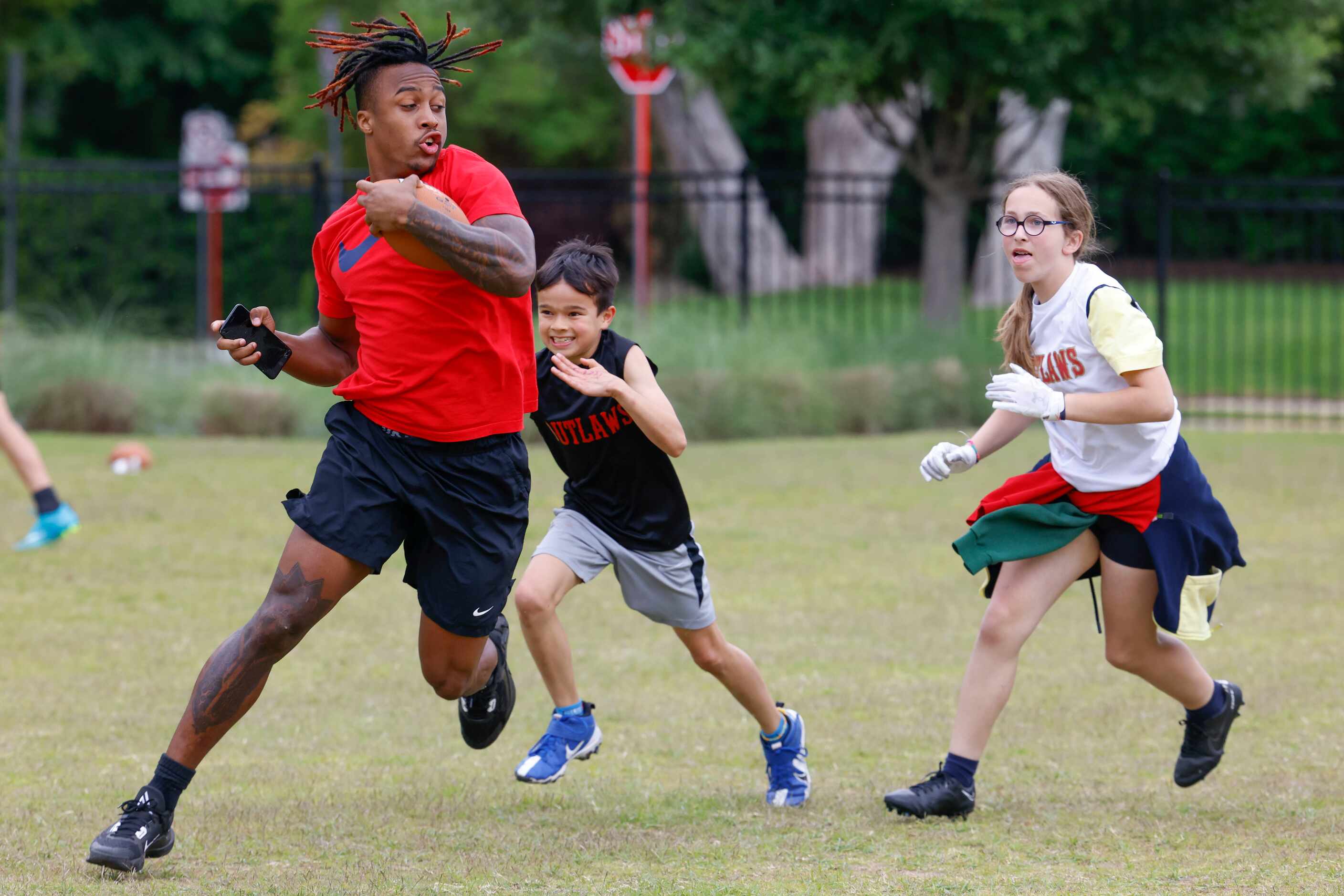 SMU’s CJ Sanders runs past the kids during a special session of football drills and practice...