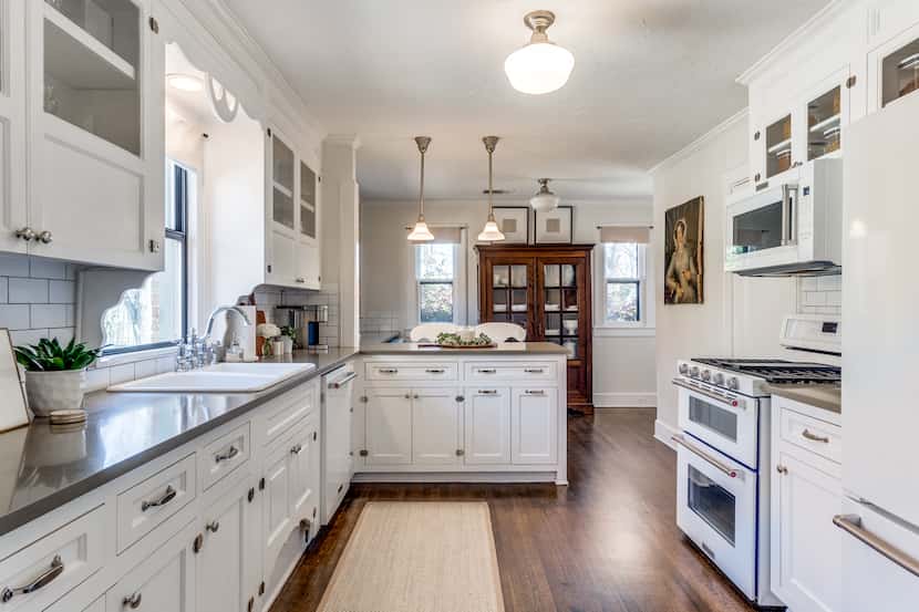 A kitchen has an L-shaped countertop and white cabinets.