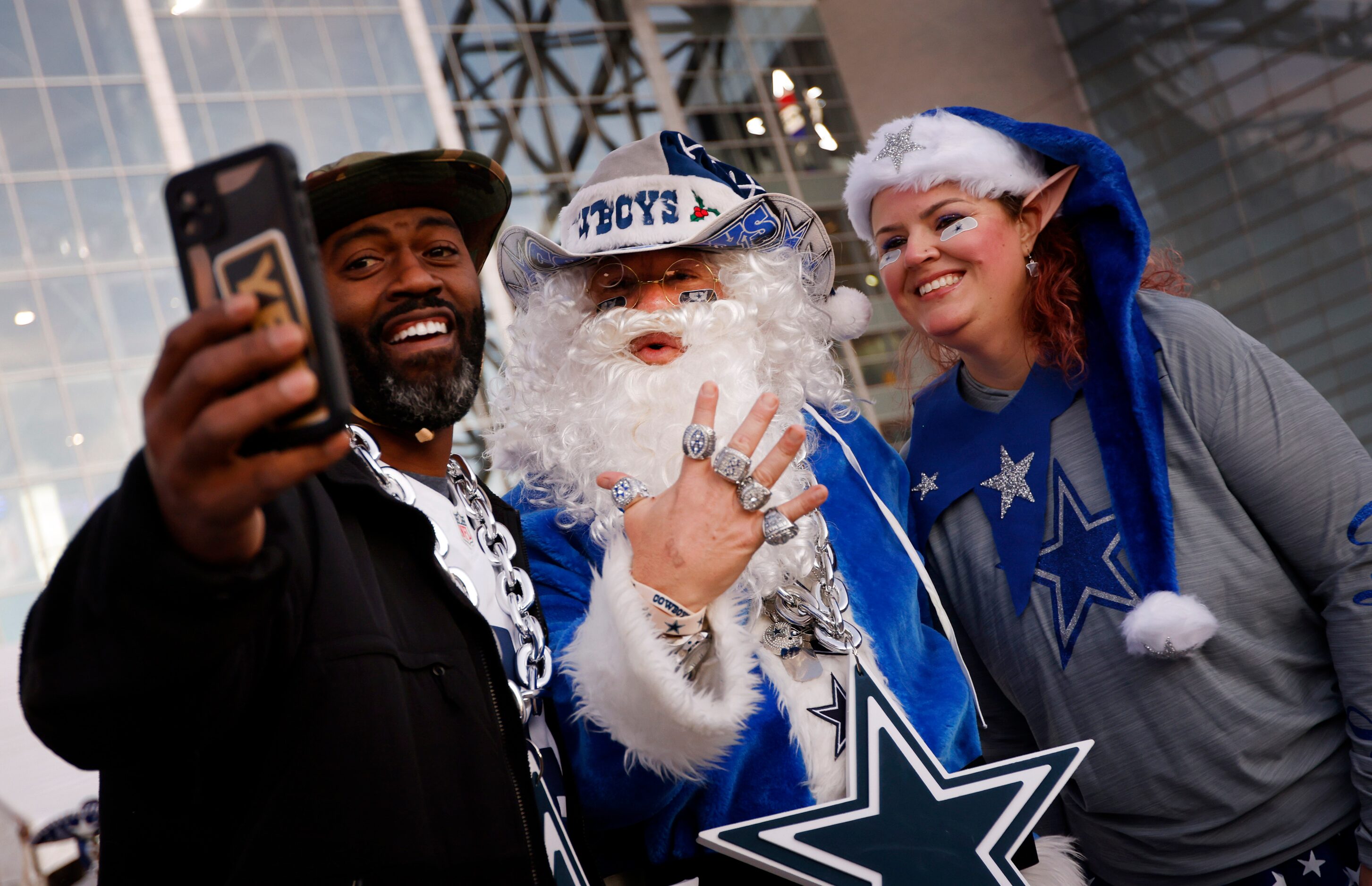 Otis Gardner of Nashville (left) takes a selfie with Christmas dressed Dallas Cowboys fans...