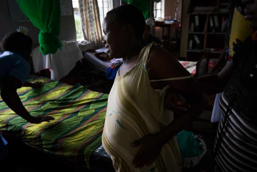 After being checked by a midwife, the mother waits while a bed is prepared so that she can...