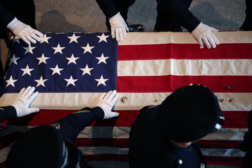 Irving police officers laid their hands on the casket of Mark Dahl on Wednesday during his...