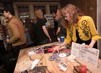 Hannah Chalker with the band Acid Carousel sells new cassette tapes during a house party in...
