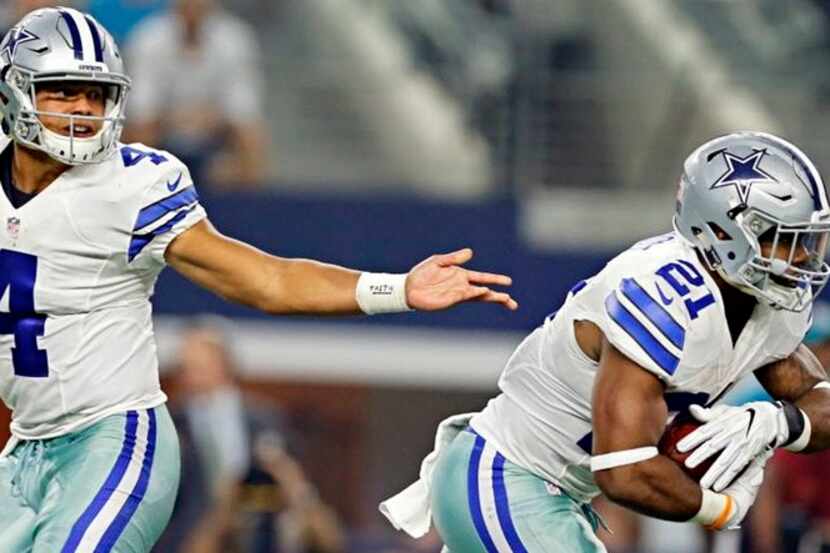 Dallas Cowboys quarterback Dak Prescott (4) hands off to running back Ezekiel Elliott during...