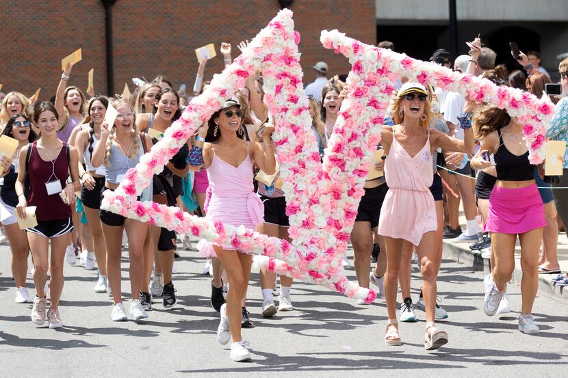A group of newly picked Delta Gamma sorority pledgees run out of Bryant-Denny Stadium to...