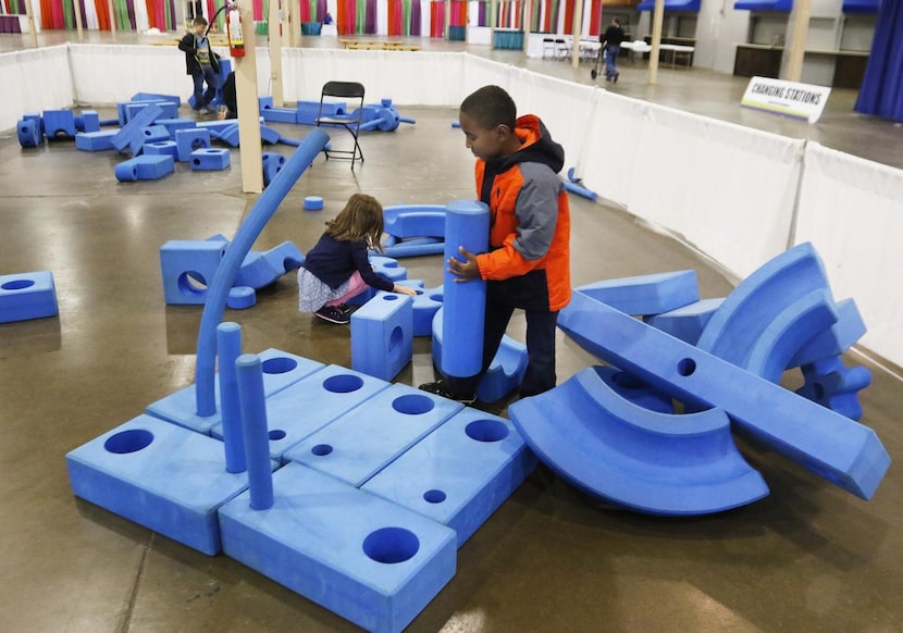 
Ava Meyers, 5, and Noah Cypull, 8, play in the Imagination Playground at Fair Park....