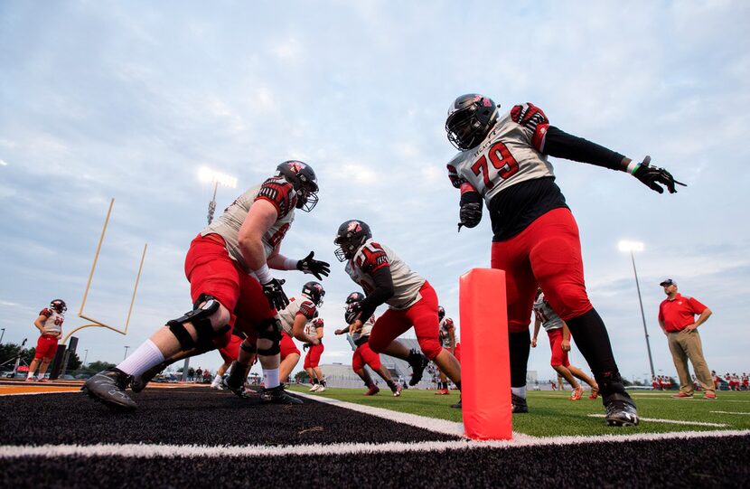 Mansfield Legacy senior linemen Rodney Jones (79) and Clayton Franks (64), left, warm up...