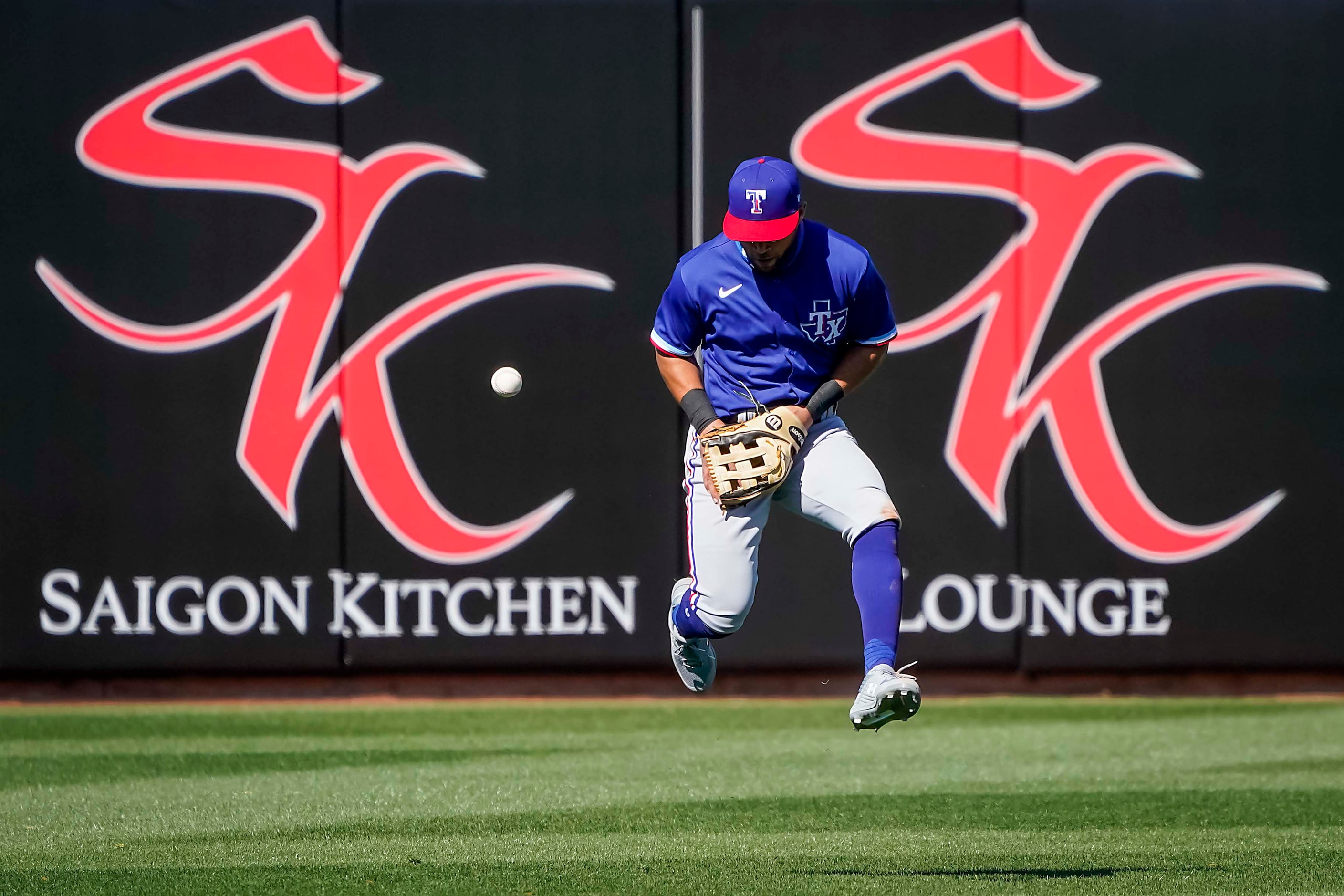 Texas Rangers outfielder Jason Martin can’t makt the play on a single off the bat of Kansas...