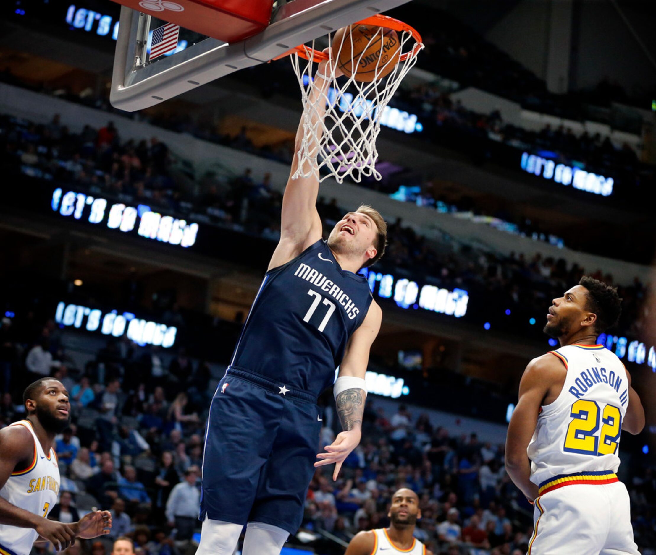 Dallas Mavericks forward Luka Doncic (77) dunks the ball over Golden State Warriors forward...