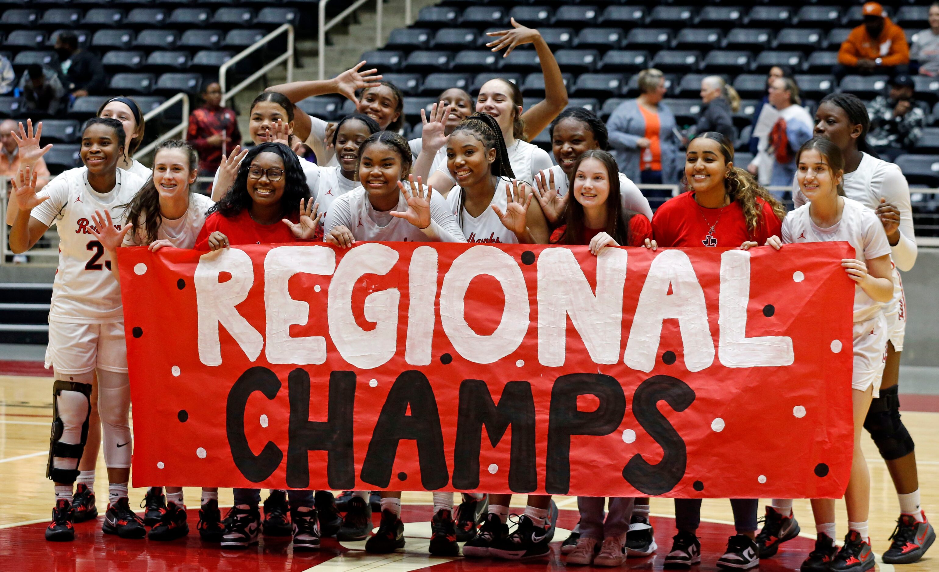 The Frisco Liberty High girl’s basketball team hold a “Regional Champs” banner, after...