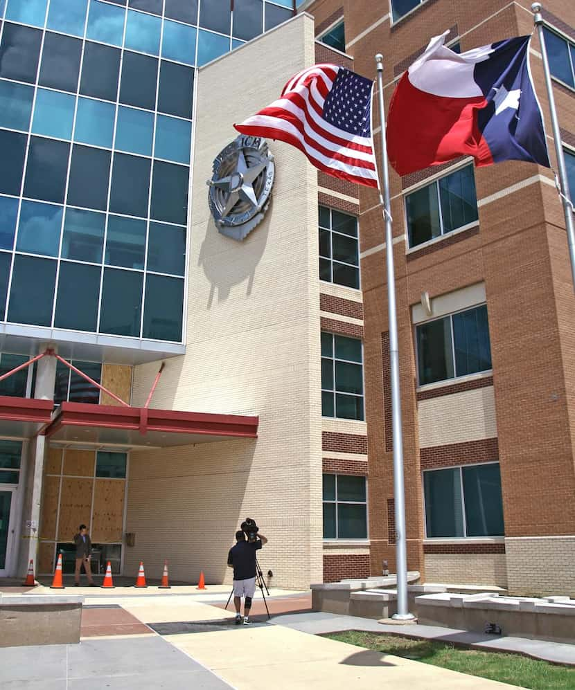 
Windows were boarded up Sunday at the Jack Evans Police Headquarters as a TV crew taped a...