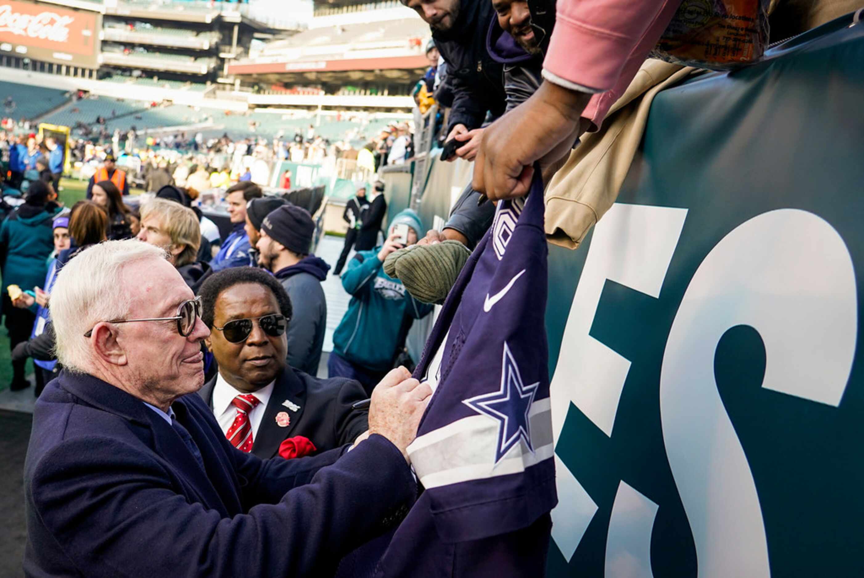 Dallas Cowboys owner Jerry Jones signs autographs for fans before an NFL football game...