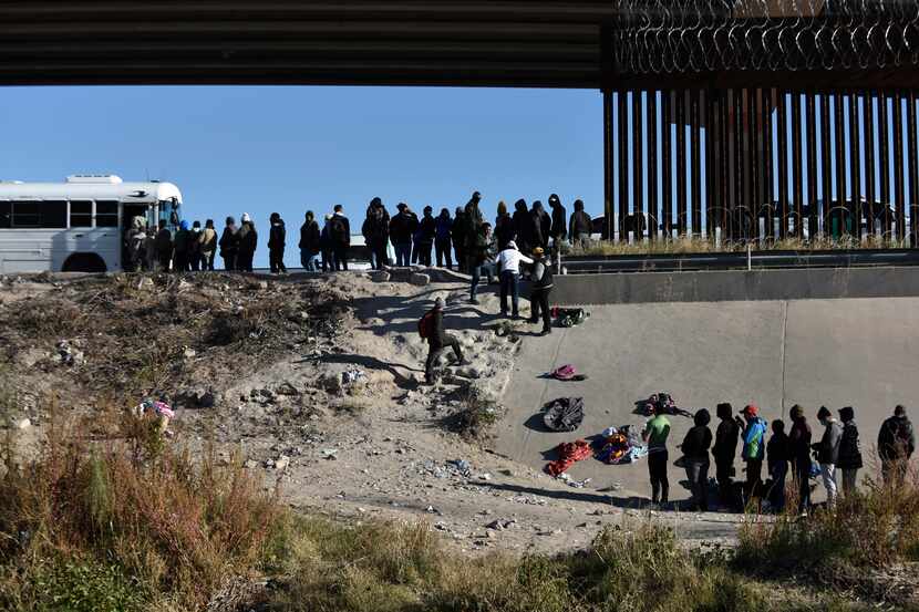 Migrants waited to get into a U.S. government bus after crossing the border from Ciudad...