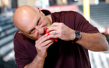 Dallas Morning News’ Rangers reporter Evan Grant takes a bite of the Texas Taco as he and...