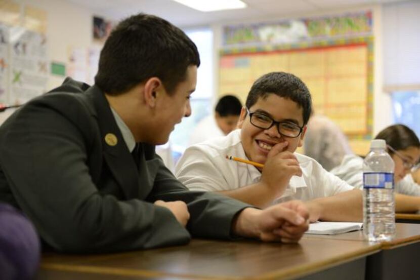 
Bobby Carter, a freshman football player at North Dallas High School, helps fifth-grader...