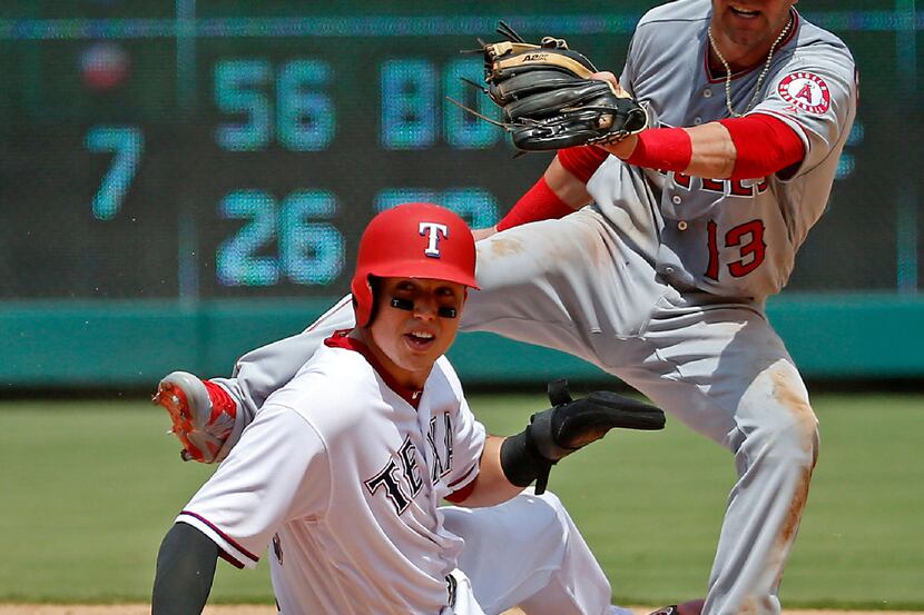 Los Angeles Angels second baseman Nick Franklin (13) falls down after being pushed by Texas...